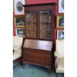 An Edwardian mahogany bureau bookcase, ogee cornice over two led glazed doors to top,