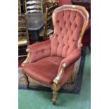 A Victorian button back armchair, scroll arms,