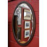 An Edwardian oval wall mirror, mahogany frame inlaid with harebells,