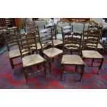 A set of nine 20th century oak rush seated ladder back chairs;