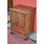 A reproduction mahogany cabinet, two crossbanded doors to cupboard over two drawers, ogee feet.