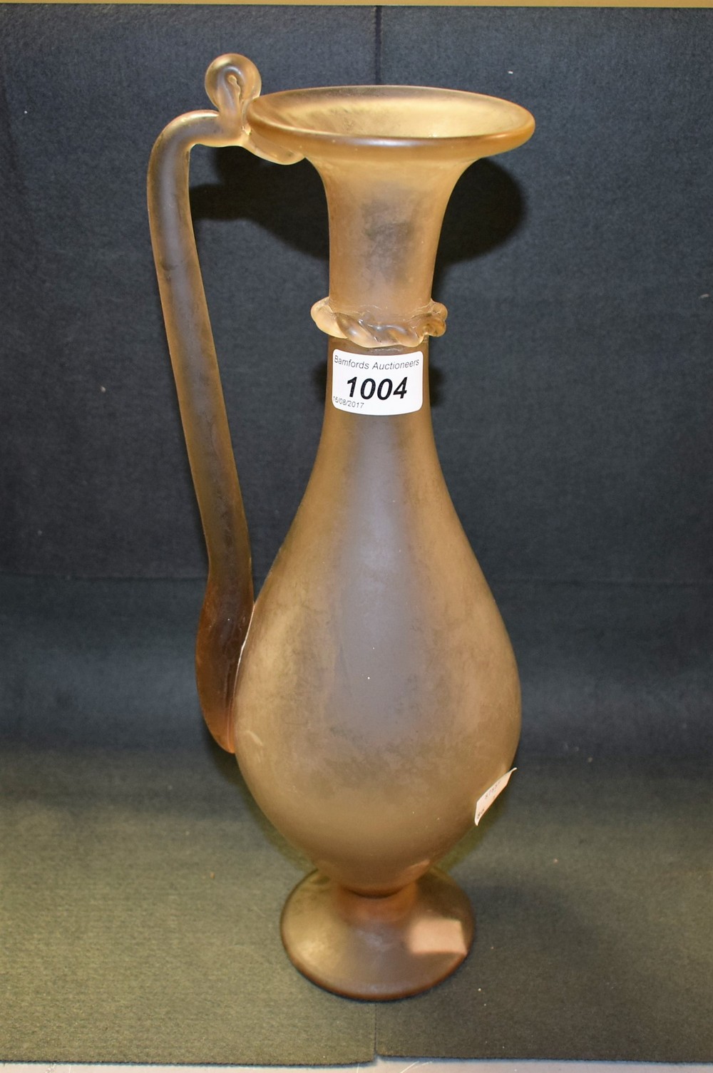 A smoked glass ewer, rope twist collar, angular handle,