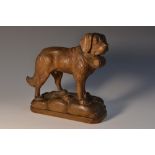 A Black Forest carving, of a St Bernard dog, he stands, a barrel at his collar, 15cm high, c.