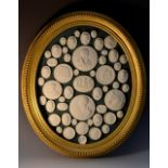 A large oval arrangement of Grand Tour plaster intaglios, 41cm x 34cm,