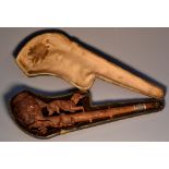 A 19th century Black Forest pipe, well carved with a dog walking along a branch,