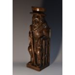 A Jacobean Revival oak carving, of an official, seated,