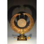 A 19th century bronze and ram's horn dinner gong, the circular chime Burmese, square base,