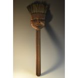 A Folk Art oak novelty brush, carved with a comical face, the bristles forming the hair,