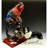 A large resin model of a Macaw Parrot on a branch,