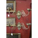 A set of four decorative brass wall lights