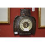 A Black Forest carved wood owl aneroid thermometer