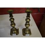 A pair of large Victorian brass candlesticks with pushers