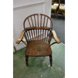 An elm Windsor chair, hoop back, outswept arm rail, spindled back, saddle seat, turned legs,