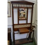 A late Victorian oak hallstand, architectural pediment, spindled back over rectangular plate,