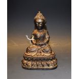 Chinese School, a dark patinated bronze, of Buddha, seated in serenity, on a lotus,