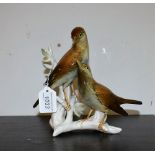A German porcelain bird group model, naturalistically painted, impressed and printed marks,