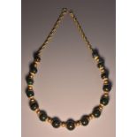 A globular bloodstone chalcedony bead and yellow metal necklace,