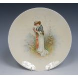 A Minton circular plate, painted by J E Dean, signed, with lady picking roses in a garden,