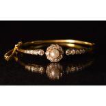 A late 19th/early 20th century diamond and pearl hinge bangle, central single creamy white pearl,