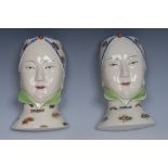 A pair of figural wall pockets, each modelled as an Oriental lady,