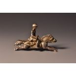 A late 19th century silver and gold coloured metal huntsman upon a galloping horse brooch,