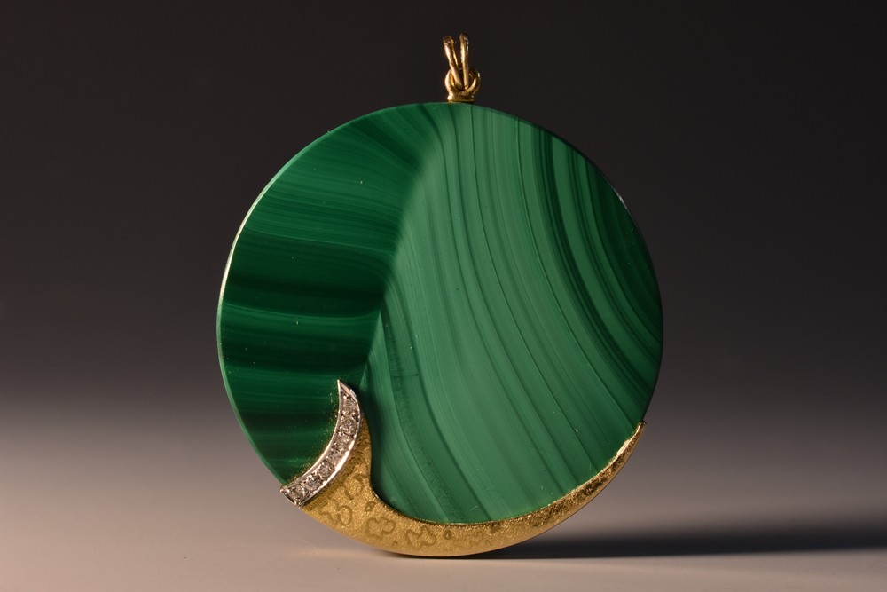 A malachite diamond set disc pendant, yellow metal frame and mount,