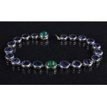 A multi stone bracelet, twenty one section articulated body inset with two green emerald cabochons,
