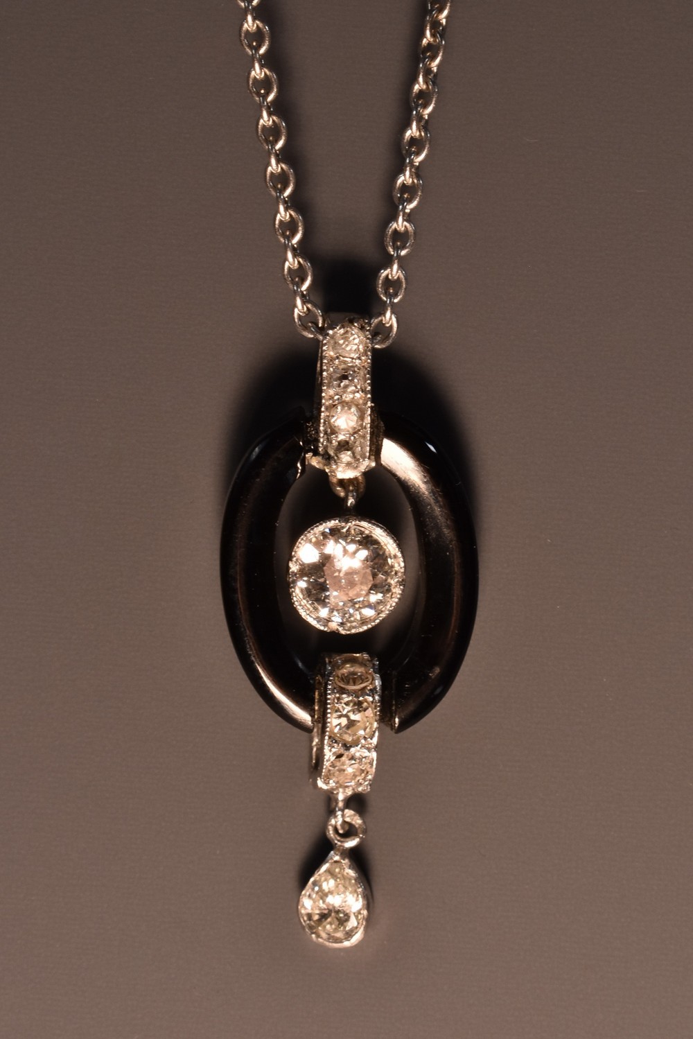 A diamond and black onyx pendant necklace,