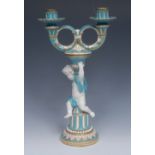 A Minton two-branch, two-light figural candlestick, with fluted nozzles, leafy ring branches,