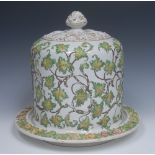 A Staffordshire Stilton dish and stand, in relief with scrolling vine, in tones of green,