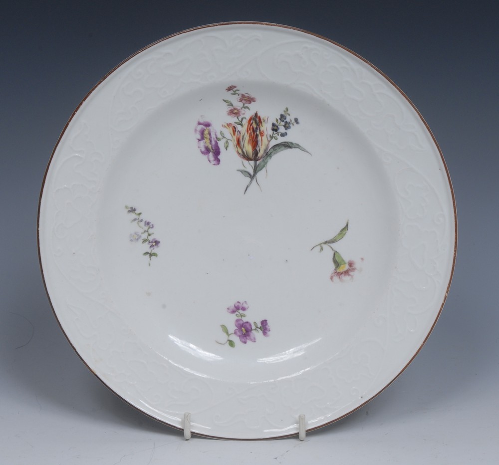 A Meissen circular plate, painted with a tulip and other flowers, scroll moulded border,