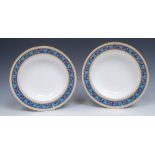 A pair of Minton soup plates, painted in the style of Sir Christopher Dresser,