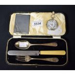 A silver lady's pocket watch; a chrome stamp case; a silver baby's fork and spoon,