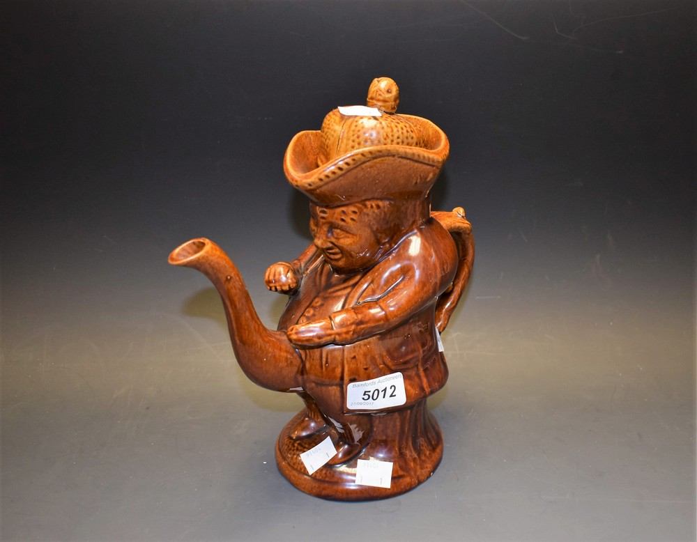 A 19th century treacle glaze Toby jug with lid