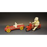 Two reproduction cast metal figures of Michelin men in a racing car and on a motorcycle