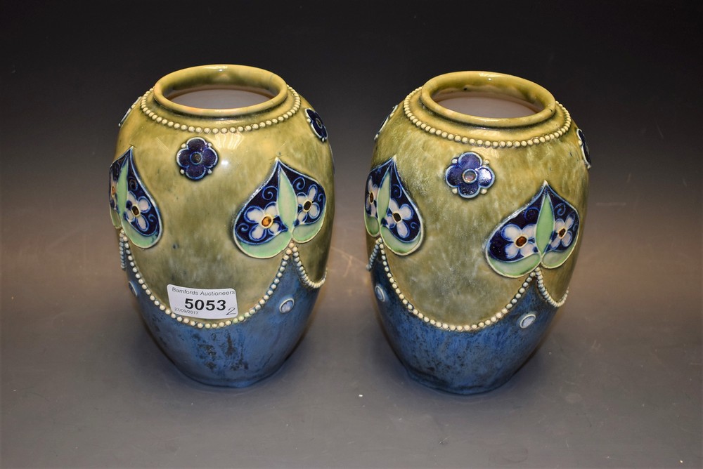 A pair of Royal Doulton ovoid vases, tube lined with flowerheads and applied with beaded borders,