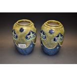 A pair of Royal Doulton ovoid vases, tube lined with flowerheads and applied with beaded borders,
