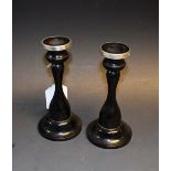 A pair of Victorian ebony and silver top candlesticks,