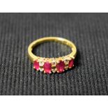 A diamond and ruby dress ring, set with four navette pinky red rubies,