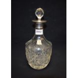 A cut glass decanter, silver rim,