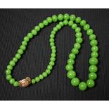A graduated single strand necklace of polished green stone beads,