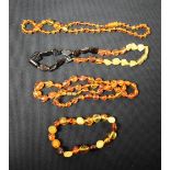 A clear amber polished necklace, single strand; another,