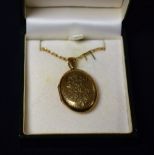 A 9ct gold oval locket, chased floral decoration and a 9ct gold chain, total weight approx.