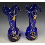 A pair of blue glass overpainted vases, frilled rim,