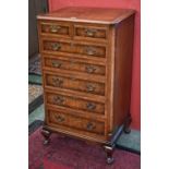 A walnut veneered tall chest, moulded top, two short drawers over five graduated long,