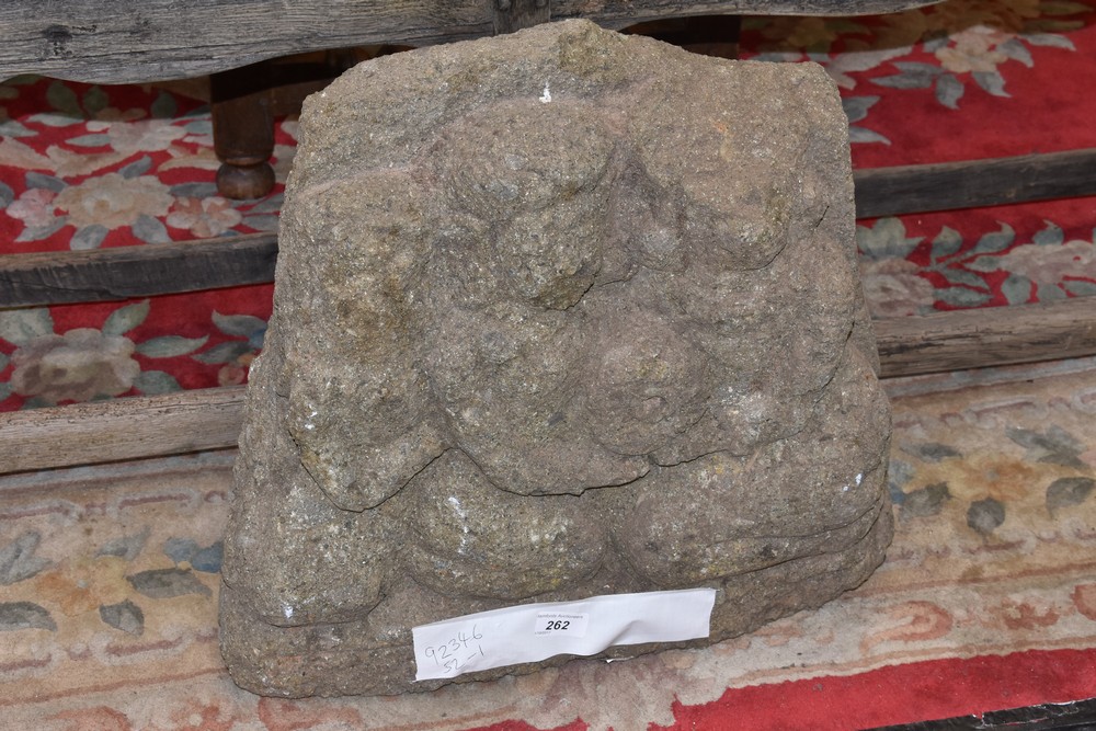 An Indonesian volcanic stone stele, carved with seated deities, 48cm high, 51cm wide, Majapahit, c.