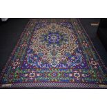 A hand woven Persian Zealous rug, floral and geometric designs in hues of green,