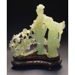 A Chinese jade figure group, carved with two ladies, wearing flowering robes by blossoming branches,