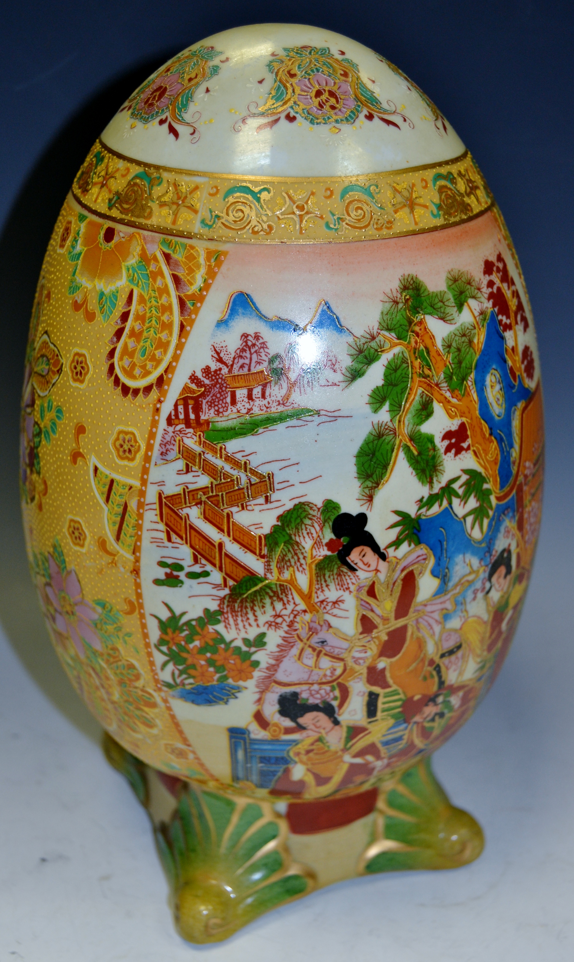 An Oriental Satsuma temple egg, hand painted with rural scenes,