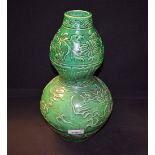 A Chinese green double gourd vase, decorated with dragons and foliage,